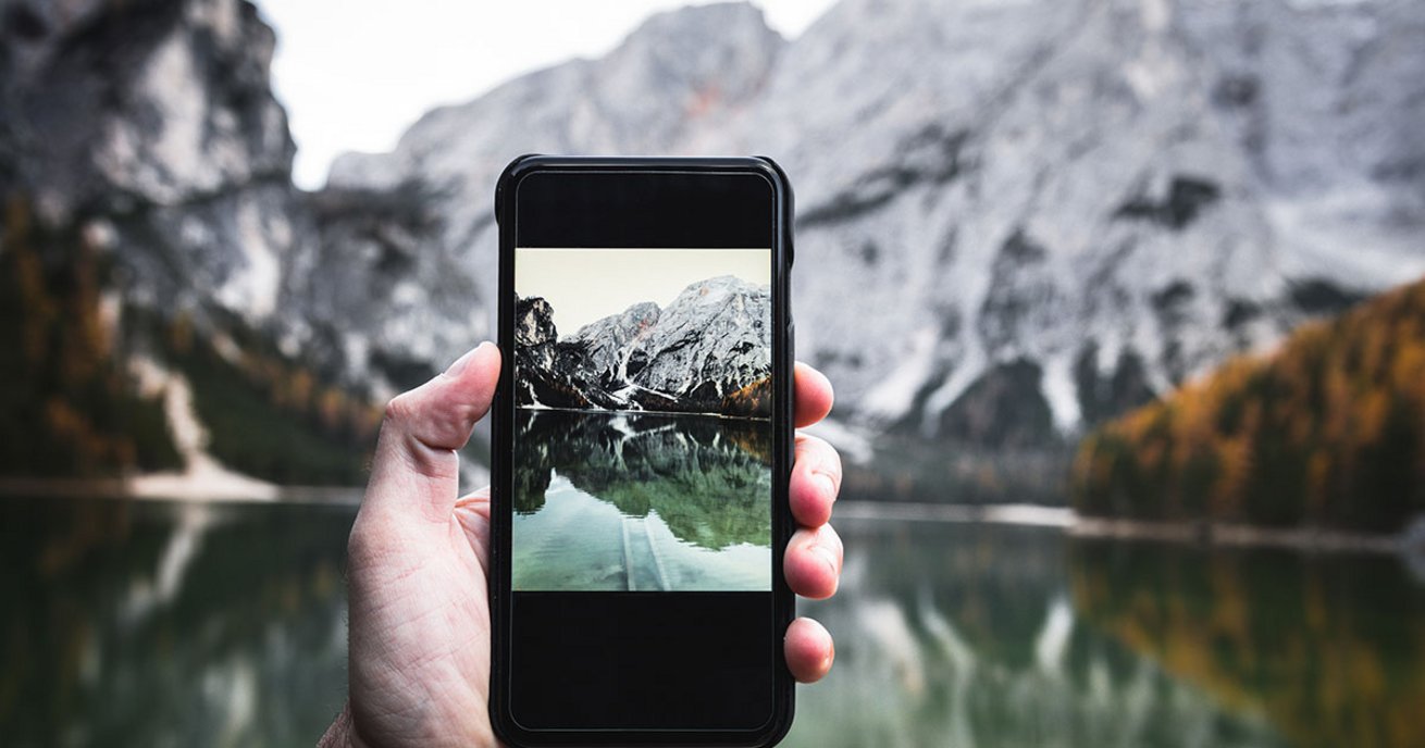 Berge Hand mit Handydisplay 