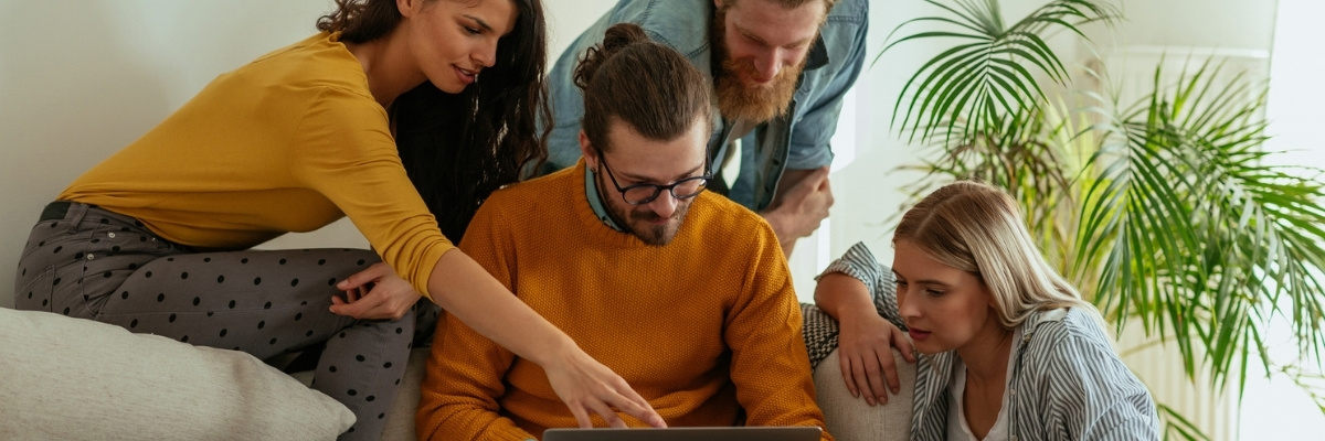 Zwei Pärchen auf Couch mit Laptop